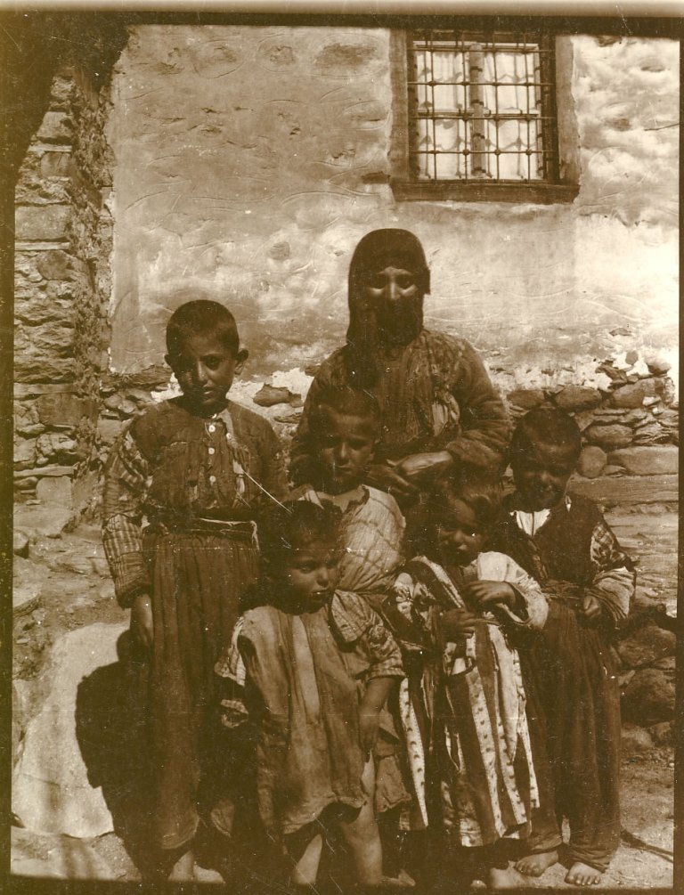 Bodil Biørns tekst på baksiden "Heghin med sine 5 sønner, 2 blev opptatt i barnehjemmet. Innebrent under myrderiene i Musch i 1915. Hjalp oss i hjemmet med sønn. Hun var en snild, troende kvinne."